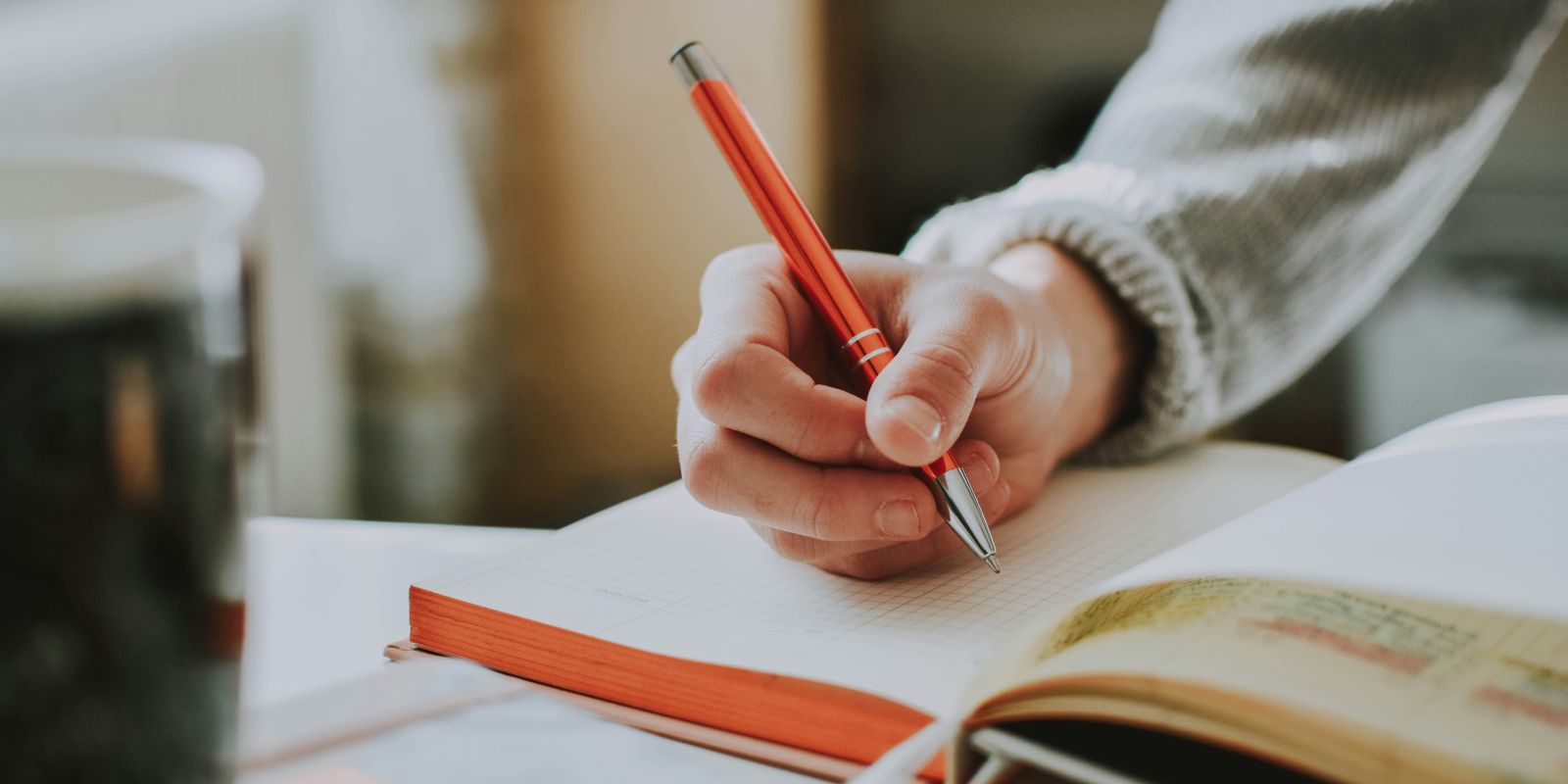 a student holding a pen and writing on a book