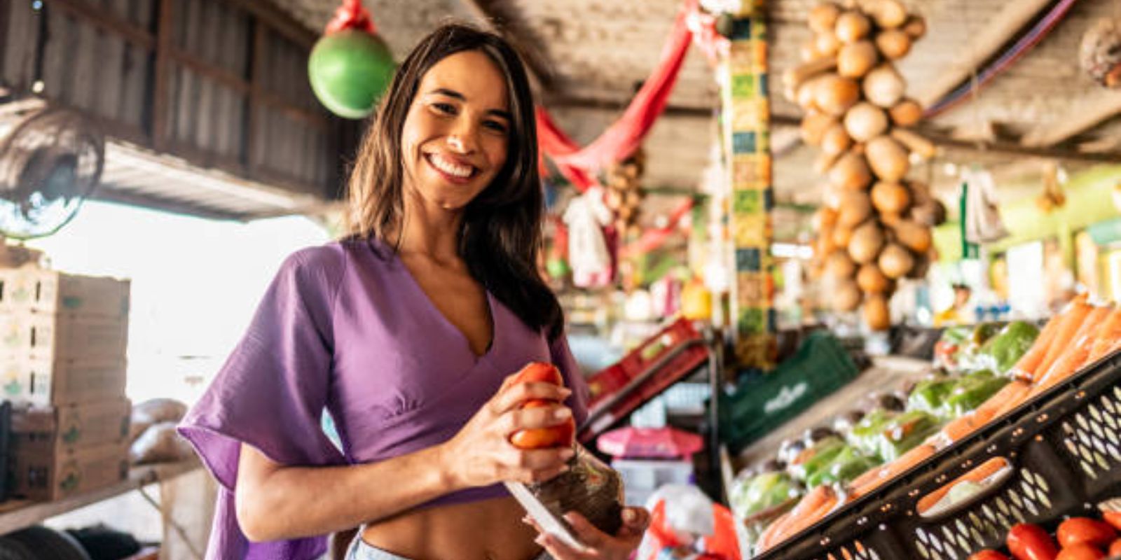 Portrait of a young woman choosing fruit at a street market