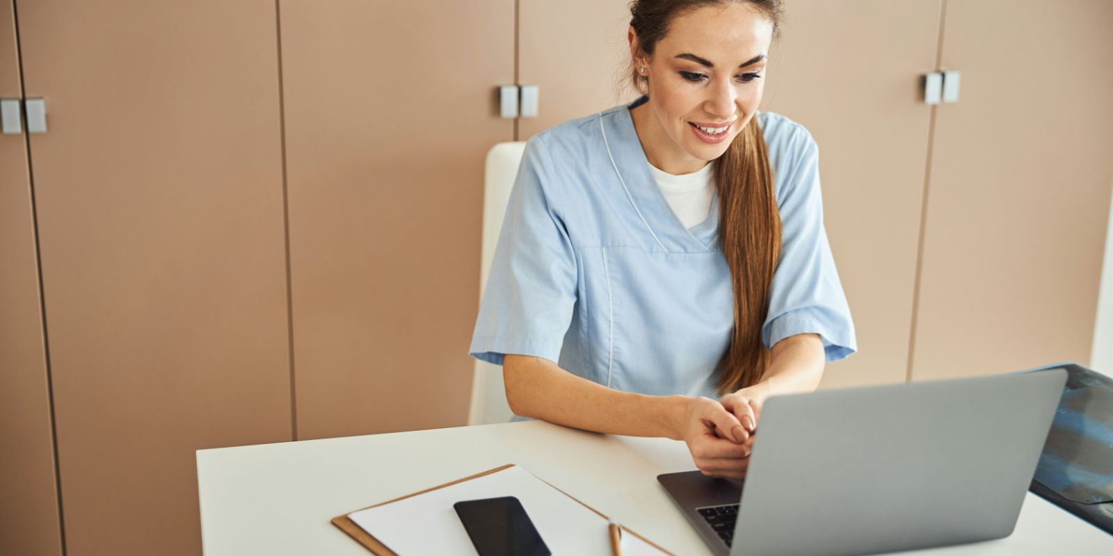 A person sitting in front of a laptop, focused on the screen.