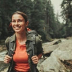 A young woman traveling near mountain river.