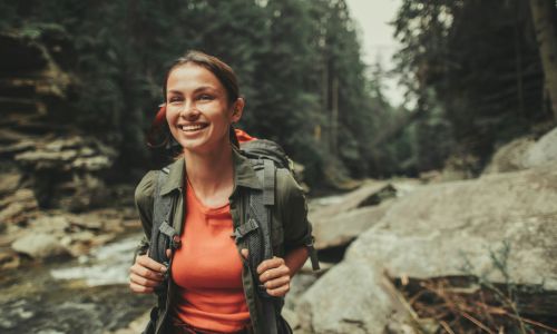 A young woman traveling near mountain river.