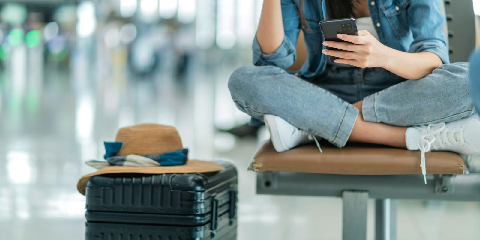 Traveler sitting cross-legged at an airport.
